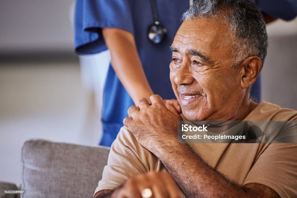 Nurse or doctor offer their man support during recovery or loss. Caregiver holding hand of her sad senior patient and showing kindness while doing a checkup at a retirement, old age home or hospital