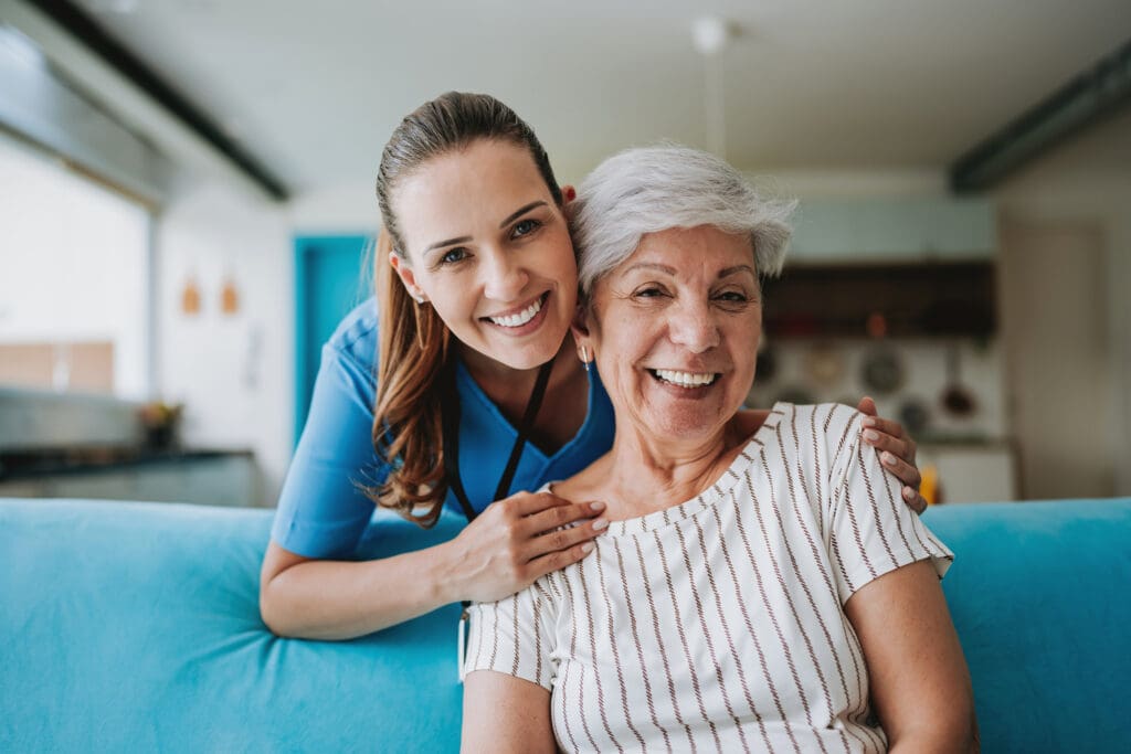 A health care worker hugs a patient in their own home.